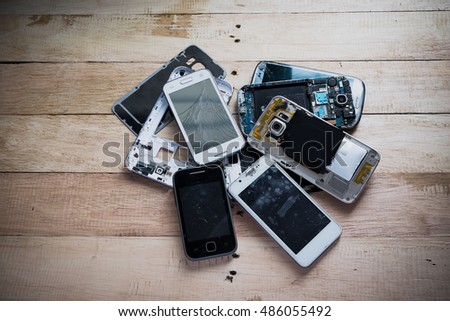 Broken smart phone with tone and wooden texture background