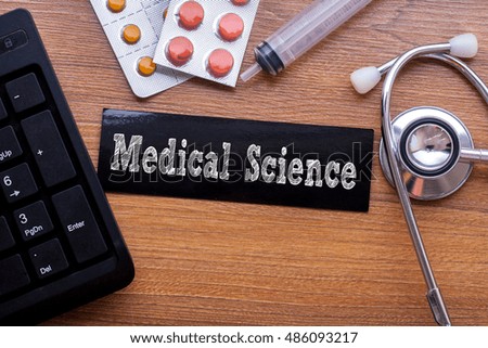 Medical Science words written on label tag with medicine,syringe,keyboard and stethoscope with wood background,Medical Concept