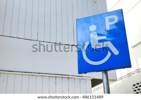 reserved parking sign for handicapped people with office building in background