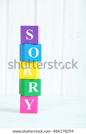 Colorful wooden toy cubes on a blue wooden background