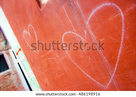 Heart sign drawn by white chalk on a wall