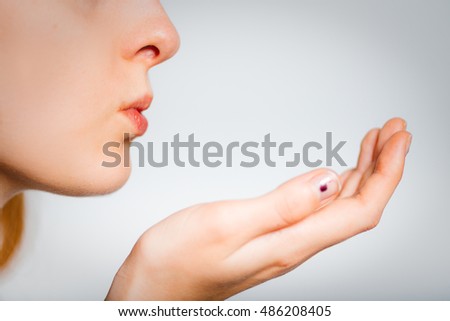 Redhead young woman holding something on the palm of delicate, isolated close-up