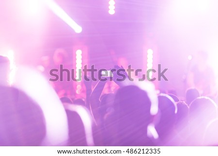 Crowd at a concert. Fun with his hands up and smartphones.