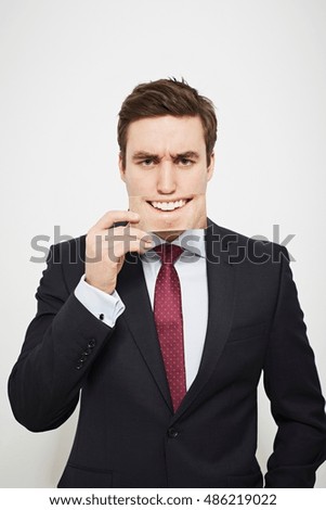 Businessman holding angry picture over his face