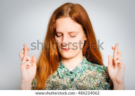 Redhead young woman praying, isolated close-up