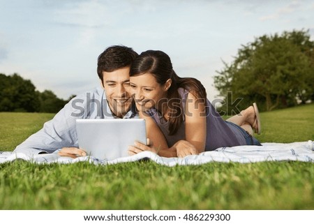 Mid adult couple using digital tablet