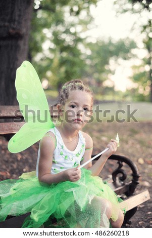 Girl in a green fairy costume with wings
