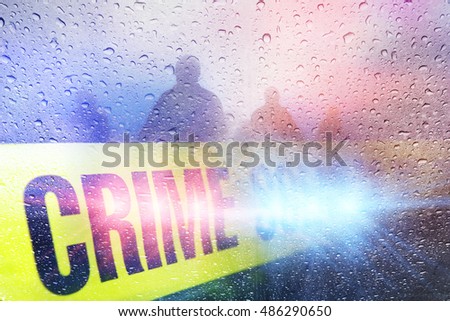 Police crime scene with lights, police tape and raindrops with silhouettes in the background