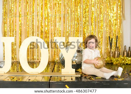 girl sitting on the floor laughing and having fun throwing confetti New Year