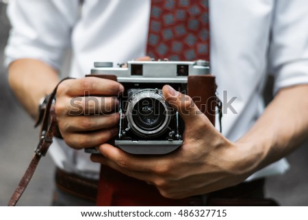 Boy who keeps camera on hands with retro style