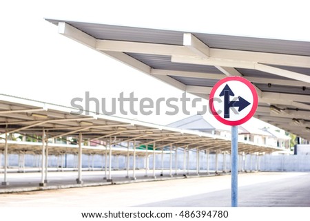 Traffic sign on empty car parking lot with roof background