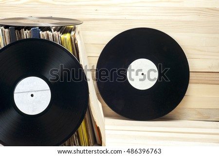 Vinyl record in front of a collection of albums, vintage process. Copy space for text.