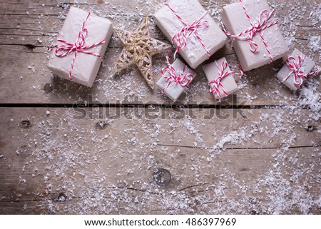Many wrapped christmas presents  on aged wooden background. Selective focus. Top view. Place for text. Drawn snow effect.