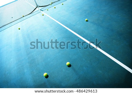 Tennis court with tennis balls intentionally shot with surreal dramatic tone. Shallow depth of field.