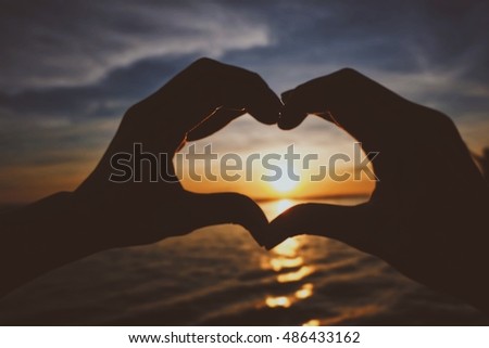 Love shape hand silhouette and blurred background