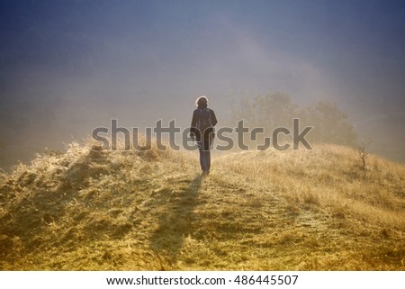 Photographer taking photos in autumn mountains in sunrise
