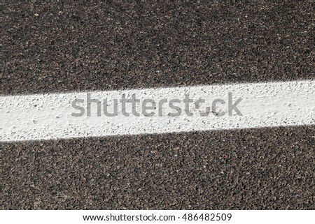   photographed close-up of road marking is located on the roadway, white line on the pavement