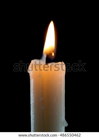 candle lit brightly against a black background