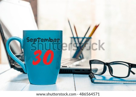 September 30th. Day 30 of month, calendar on hot cacao cup at translator or interpreter workplace background. Autumn time. Empty space for text