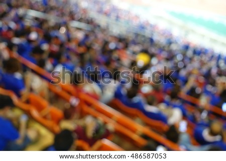 Blurred picture for background use :View of people are watching football sport in stadium .
