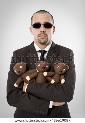 Executive portrait hugging a teddy bears on neutral background