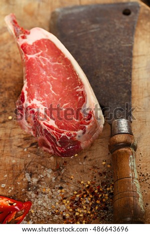 raw beef meat steak on wooden table with meat cleaver and spices