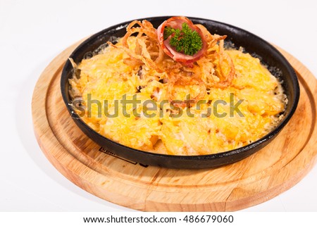 fried potatoes with cheese and meat on black pan