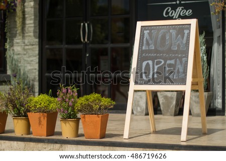 White 'Open' sign on black board with coffee cafe