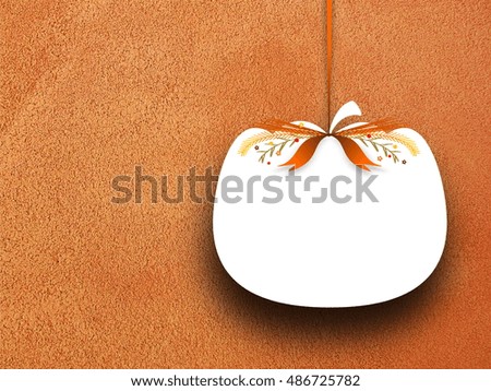 Close-up of one blank pumpkin shaped frame hanged by brown ribbon on rough orange concrete wall background