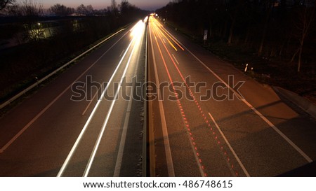 Winding Motorway at night, long exposure of headlights and taillights in blurred motion