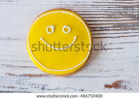 Smiley face cookie. Biscuit with yellow frosting. How to transfer good mood. Dessert that makes you smile.