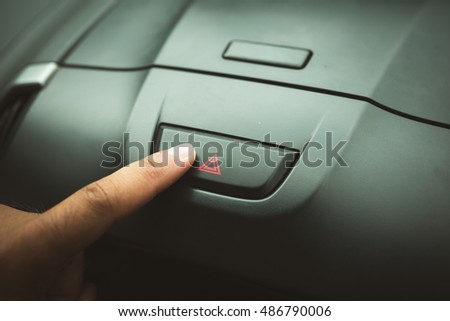 finger hitting car emergency light botton, man pressing red triangle car hazard warning button
