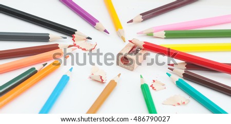 Colored pencils and sharpener on white. Photos school supplies
