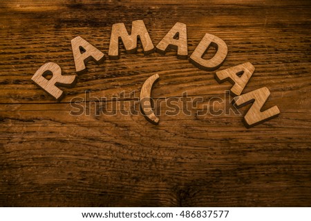 Image of word RAMADAN on wooden background, close up. empty copy space for inscription or other objects. Religion and holiday backdrop. Moon made from wood
