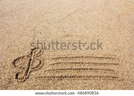 Treble clef drawn on sand on seashore