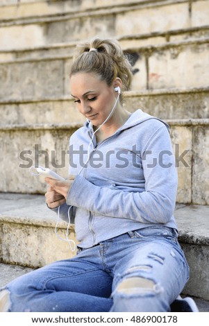 Young woman listening music with mobile phone outdoor