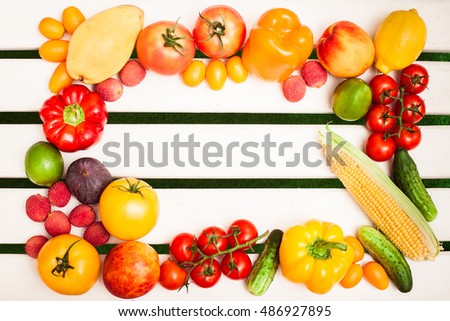 Juicy fruits and vegetables in a circle at the white boards background. Free space for text in the center. Top view.