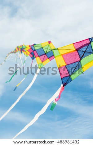 Colorful multi-color kites flying in blue sky 