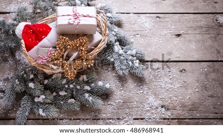 Christmas presents, fur tree and decorative star and Santa hat on aged wooden background. Selective focus.  Place for text. 