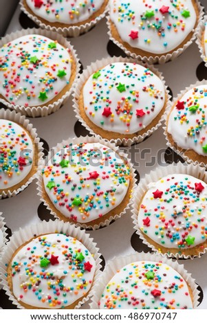Vanilla cupcakes with white glaze, cupcake packaging, delivery box, top view, selective focus, close up