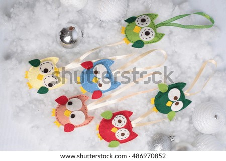 Handmade Christmas decorations. Funny Christmas owls and balls on snow