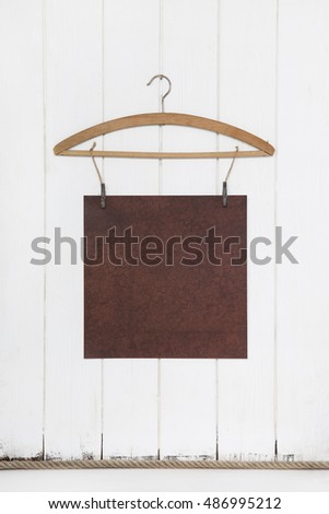 Old white brown paper hanging on a coat hanger. Mock up concept in old style empty and nobody.