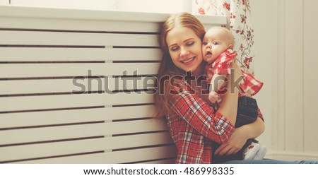happy family mother and baby playing at home window