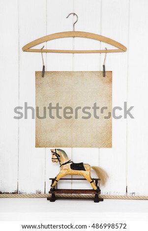 Old antique and ancient rocking horse with an old grunge paper as vintage background for a christmas greeting card.