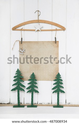 Three wooden green christmas trees with an old paper background in white and beige in mock up style for a text.