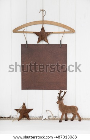 Shabby chic christmas background with an old paper and a reindeer on wooden white background.