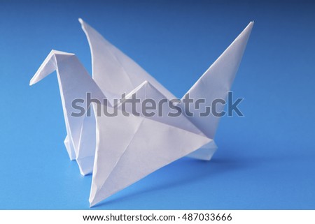 origami paper crane on blue background
