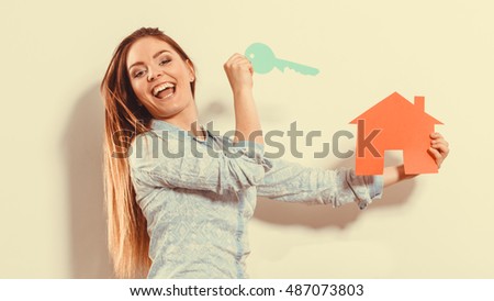 Happy young woman girl holding red paper house and key dreaming about new home house. Housing and real estate concept. Instagram filter.