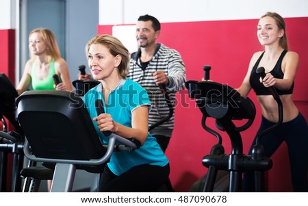 Active adult people in a fitness club working out at group class