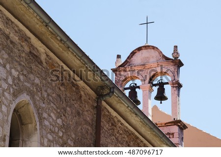 Close up of old historical christian tower bell. Medieval catholic church with bells and cross.